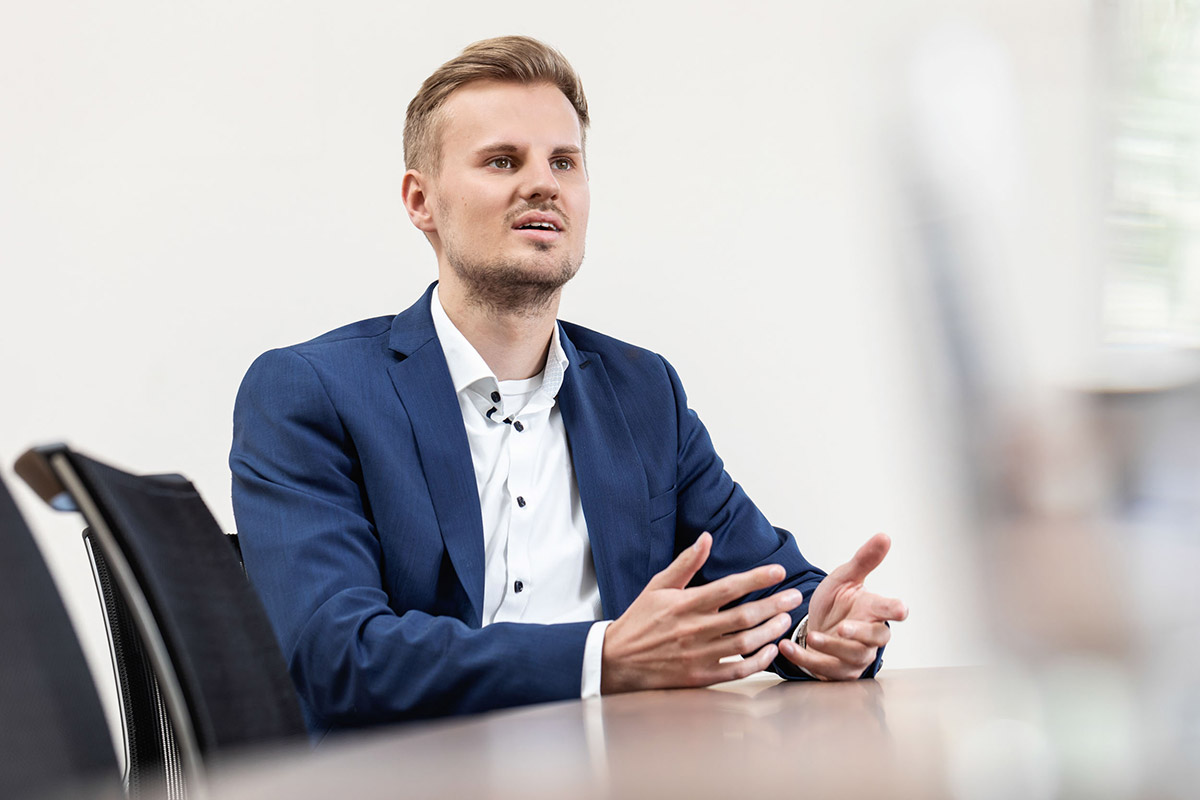 Immobiliendarlehensvermittlicher Simon Wührl inmitten einer Besprechung im Brüo von Henneberger Finanzierung aus Würzburg