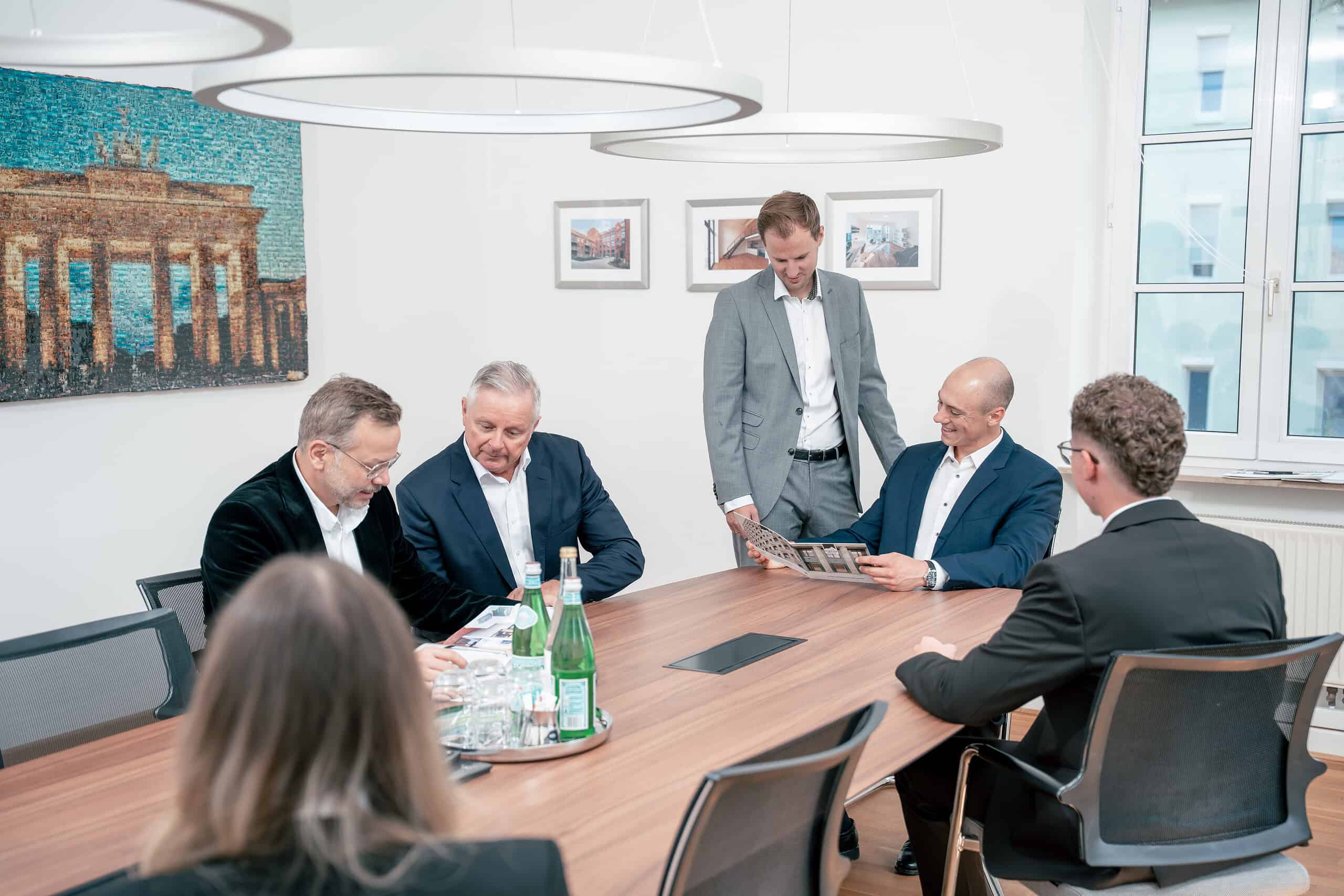 Mitarbeiter der Henneberger Finanzierung sitzen am Besprechungstisch und planen gemeinsam das nächste Projekt